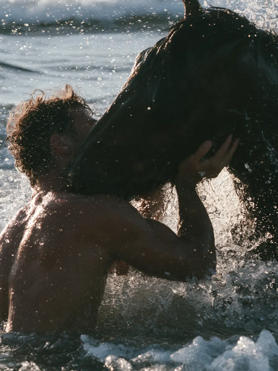 A swimmer with his horse in the sea