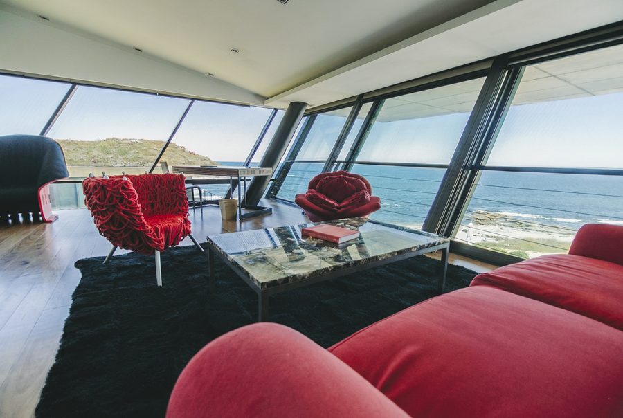 Caras Suite at Playa Vik: red armchairs and the Atlantic through the glass